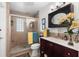 Bathroom featuring tiled shower with glass door, framed mirror, and vanity at 230 32Nd N Ave, St Petersburg, FL 33704