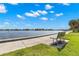 Picturesque waterfront view featuring a bench for relaxation and enjoyment of the serene landscape and clear blue sky at 230 32Nd N Ave, St Petersburg, FL 33704