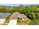 Aerial shot of a well-maintained home with lush landscaping and a large driveway, nestled near a forest at 26249 Sword Dancer Dr, Wesley Chapel, FL 33544