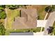 Aerial view of a house with a brown roof, green backyard and nearby road, showcasing the property's layout at 26249 Sword Dancer Dr, Wesley Chapel, FL 33544