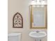 Powder room features a pedestal sink, decorative mirror, and tile flooring at 26249 Sword Dancer Dr, Wesley Chapel, FL 33544
