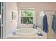 Bathroom showcasing a large soaking tub under a window at 26249 Sword Dancer Dr, Wesley Chapel, FL 33544