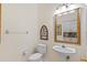 Powder room features a pedestal sink, decorative mirror, and tile flooring at 26249 Sword Dancer Dr, Wesley Chapel, FL 33544