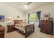 Bright bedroom featuring a bed with colorful quilt, ceiling fan, and dark blue curtains at 26249 Sword Dancer Dr, Wesley Chapel, FL 33544