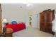 This cozy bedroom features a daybed with red quilt, a ceiling fan, and an elegant wardrobe at 26249 Sword Dancer Dr, Wesley Chapel, FL 33544