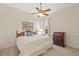 Bedroom with carpet, ceiling fan, traditional furniture, and a window overlooking the backyard at 26249 Sword Dancer Dr, Wesley Chapel, FL 33544