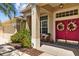 Cozy front porch showcasing a vibrant double door and a comfortable seating area at 26249 Sword Dancer Dr, Wesley Chapel, FL 33544