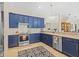 Kitchen with stainless steel appliances, blue cabinets, and tile backsplash at 26249 Sword Dancer Dr, Wesley Chapel, FL 33544