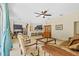 Open-concept living room with tile floors, ceiling fan, view of the backyard and kitchen at 26249 Sword Dancer Dr, Wesley Chapel, FL 33544