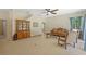 Living room with tile floors, ceiling fan, curtains, a wooden display cabinet, and comfortable furniture at 26249 Sword Dancer Dr, Wesley Chapel, FL 33544