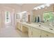 Bathroom featuring double sinks, a long vanity, and natural light from large windows at 26249 Sword Dancer Dr, Wesley Chapel, FL 33544