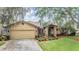 Charming single-Gathering home boasts a well-manicured front lawn, mature trees, and a two-car garage for ample parking at 2664 Frisco Dr, Clearwater, FL 33761