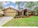Charming home showcasing a two-car garage, brick accents, manicured landscaping, and a well-kept lawn at 2664 Frisco Dr, Clearwater, FL 33761