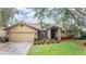 Inviting front exterior of a home featuring manicured landscaping, brick accents, and a spacious two-car garage at 2664 Frisco Dr, Clearwater, FL 33761