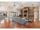 Bright living room featuring hardwood floors, a stone fireplace, a ceiling fan, and access to the pool area at 2664 Frisco Dr, Clearwater, FL 33761