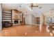 Bright living room with wood floors, a stone fireplace with built-in shelves, and a high ceiling with a ceiling fan at 2664 Frisco Dr, Clearwater, FL 33761