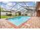 Backyard pool with brick paver deck and screened enclosure at 2664 Frisco Dr, Clearwater, FL 33761