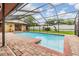 A pristine pool is surrounded by lush greenery and a privacy fence, creating a serene backyard oasis at 2664 Frisco Dr, Clearwater, FL 33761