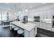 Open-concept kitchen with a large island, stainless steel appliances, and seamless flow into the dining area at 27052 Paradise Shores Dr, Englewood, FL 34223
