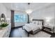 Bright main bedroom features a large window, decorative chandelier, and hardwood floors at 27052 Paradise Shores Dr, Englewood, FL 34223