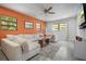 Cozy living room with white sectional sofa, a ceiling fan, and natural light from the windows at 2821 Marconi St, Tampa, FL 33605