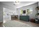 Open living space with a small bar area, modern floors, and view of the bright white kitchen at 2821 Marconi St, Tampa, FL 33605