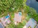 Aerial shot of a home with a screened-in pool, nestled amongst lush greenery and near a tranquil pond at 3728 Cypress Meadows Rd, Tampa, FL 33624
