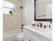 Modern bathroom with white marble tile, black fixtures, and a sleek vanity with ample counter space at 3728 Cypress Meadows Rd, Tampa, FL 33624
