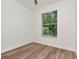 Bright bedroom with wood-look floors, white trim, white walls and a window to the back yard at 3728 Cypress Meadows Rd, Tampa, FL 33624
