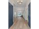 Bright foyer with light wood floors, chandelier lighting, and a view of the pool in the back at 3728 Cypress Meadows Rd, Tampa, FL 33624