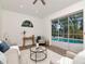 Well-lit living room with modern furnishings and a view of the pool through sliding glass doors at 3728 Cypress Meadows Rd, Tampa, FL 33624