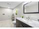 Bathroom with a granite vanity, dark wood cabinets, a toilet, and a mirror hanging above the sink at 37401 Magnolia Ave, Dade City, FL 33523