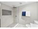 Bathroom featuring a shower with gray tile and a recessed shelf at 37401 Magnolia Ave, Dade City, FL 33523
