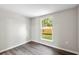 Well-lit bedroom features a neutral color palette, wood-look flooring, and a bright window at 37401 Magnolia Ave, Dade City, FL 33523
