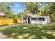 Quaint home displaying a manicured lawn, fresh landscaping, and a natural fence at 37401 Magnolia Ave, Dade City, FL 33523