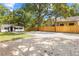 View of charming houses with a white house with black trim and a spacious parking area with a privacy fence at 37401 Magnolia Ave, Dade City, FL 33523
