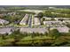 Overhead view of a residential community with lush trees, a pond, and well-maintained streets at 3844 Silverlake Way, Wesley Chapel, FL 33544