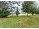 Lush green lawn extends to a serene lake, framed by mature trees at 3844 Silverlake Way, Wesley Chapel, FL 33544