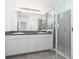 Bright bathroom featuring double sink vanity with granite countertop and tiled walk-in shower at 3844 Silverlake Way, Wesley Chapel, FL 33544