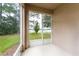 Enclosed patio offers a relaxing view of a lush green lawn and lake at 3844 Silverlake Way, Wesley Chapel, FL 33544