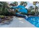 Community pool featuring a water slide, lounge chairs, and lush landscaping at 3844 Silverlake Way, Wesley Chapel, FL 33544