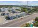Aerial view showcasing well-maintained residential buildings along a bustling street, surrounded by lush trees at 414 Finn Way # 4, Dunedin, FL 34698