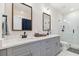 Bright bathroom showcasing a double sink vanity and glass shower with marble tiles at 414 Finn Way # 4, Dunedin, FL 34698