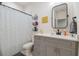 Well-lit bathroom with modern vanity, sleek mirror, shower with curtain, and ample storage at 414 Finn Way # 4, Dunedin, FL 34698