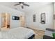 Bedroom with a TV, ceiling fan, ensuite bathroom, and ample closet space at 414 Finn Way # 4, Dunedin, FL 34698