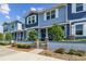 Beautiful blue townhome featuring a landscaped yard and a charming entrance with stone accents and lush greenery at 414 Finn Way # 4, Dunedin, FL 34698