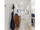 Bright hallway featuring wood floors, leading to a bathroom and front door at 414 Finn Way # 4, Dunedin, FL 34698