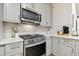 Charming kitchen featuring stainless steel appliances, gray cabinetry, and white countertops at 414 Finn Way # 4, Dunedin, FL 34698