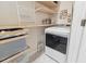 Practical laundry room with a modern washing machine and convenient built-in shelving at 414 Finn Way # 4, Dunedin, FL 34698
