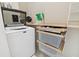 Efficient laundry room with modern appliances and built-in shelving for organized storage at 414 Finn Way # 4, Dunedin, FL 34698